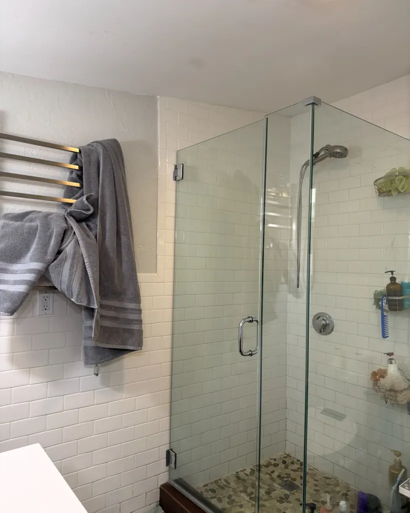Before: shower glass and towel rack before cleaning